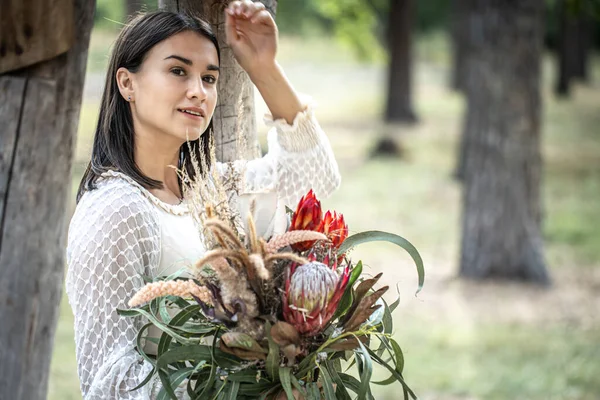 Ung Brunett Kvinna Vit Klänning Med Bukett Blommor Skogen Suddig — Stockfoto