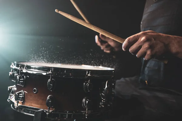 스틱을 사용하는 연주자는 스튜디오의 아래검은 배경에 튀기며 스네어 드럼을 — 스톡 사진