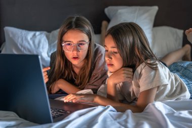 Genç kız, gözlüklü yaşlı kız ona rehberlik ederken yarış pistine uzanıyor. Rahat bir ev havasıyla sakin bir ruh hali içinde..