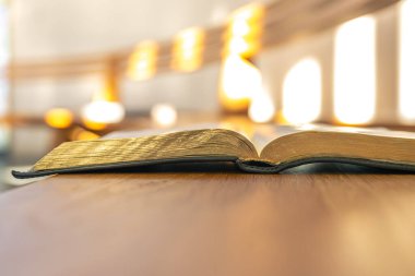 Sıcak bokeh ve ışıltı sayfaların kıvrımlarını aydınlatır ve dikkatli bir okuma havası yaratır. Modern ruhsal tasarım için yumuşak ışık ve temiz kopya alanı çalışması.