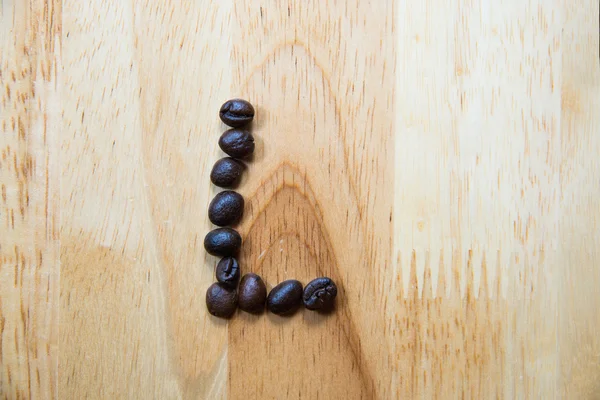 Alfabet 'L' maken van koffieboon op houten achtergrond — Stockfoto