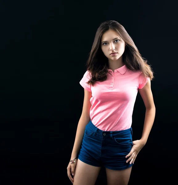 Portrait of a beautiful young brunette in the studio on a black background — Stock Photo, Image