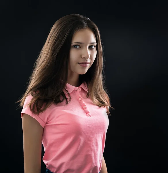 Portrait of a beautiful young brunette in the studio on a black background — Stock Photo, Image