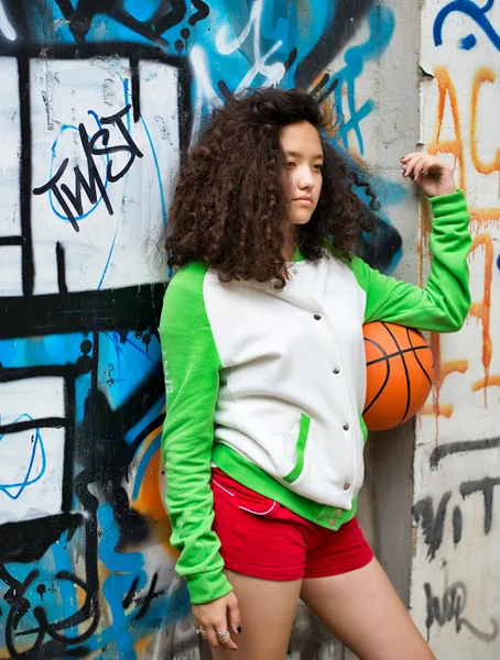 Portrait of a young brunette with a basketball in the street — Stock Photo, Image
