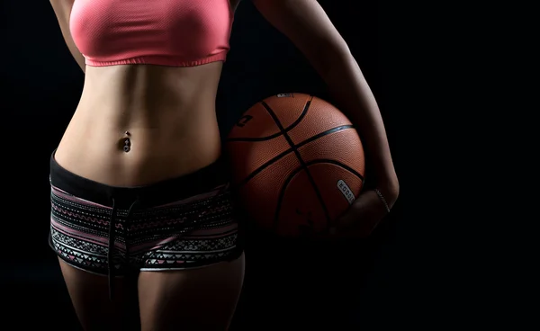 Stüdyoda basketbol topu olan güzel ve seksi bir kızın portresi.