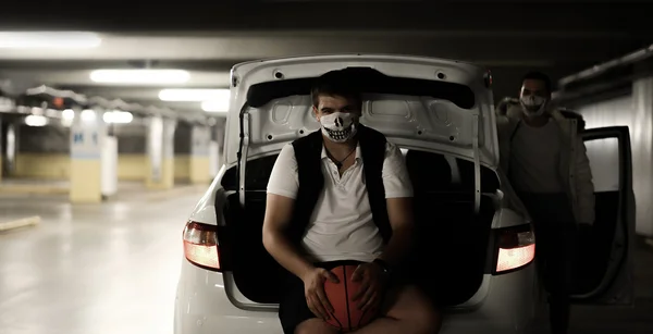 Két férfi, közvetlenül az autó a parkolóban, a kosárlabda, a maszkok portréja — Stock Fotó