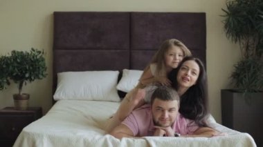 mutlu bir aile evde yatakta yatarken