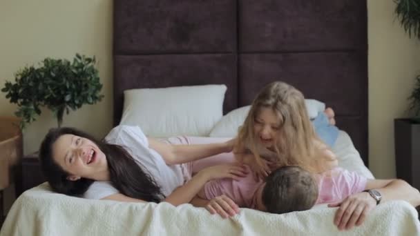 Famille heureuse couchée sur le lit à la maison — Video