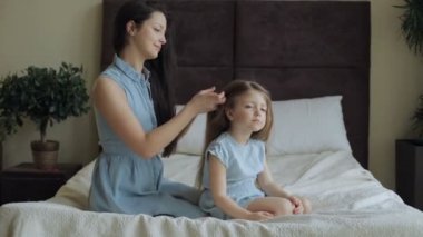 Anne evde yatakta kızı saç tarama