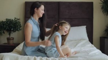 Anne evde yatakta kızı saç tarama