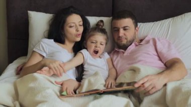 Yatakta kitap okuyarak aile kızıyla