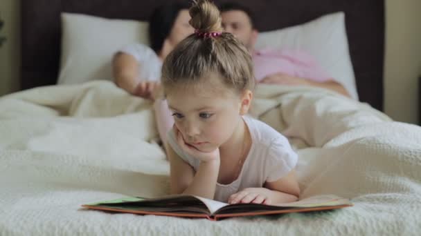 Dochter met familie, lezen van een boek in bed — Stockvideo