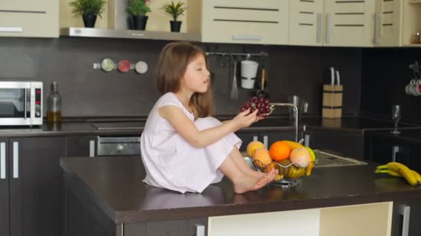 Kleines Mädchen sitzt auf dem Küchentisch — Stockvideo