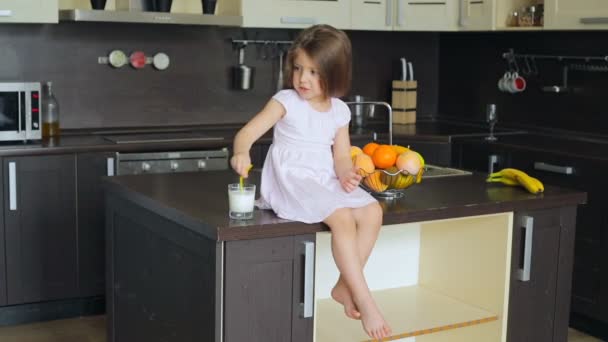 Niña sentada en la mesa de la cocina — Vídeos de Stock