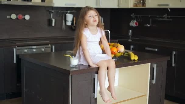 Niña sentada en la mesa de la cocina — Vídeos de Stock