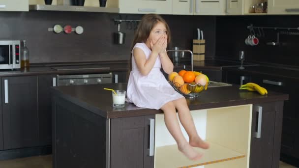 Niña sentada en la mesa de la cocina — Vídeos de Stock