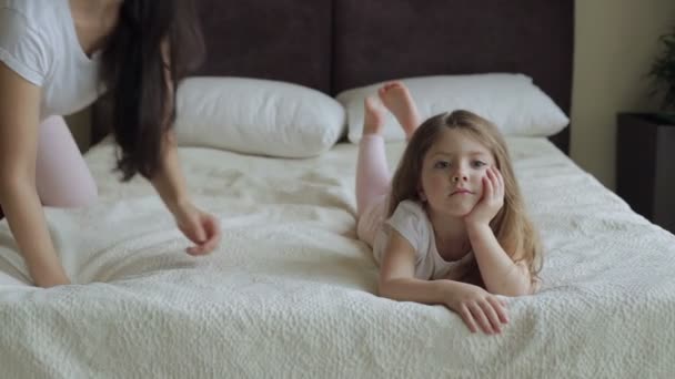 Matka i córka leżącego i gra na łóżko w domu — Wideo stockowe