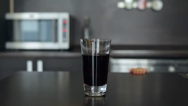 Liten flicka plockar upp ett glas juice och dryck — Stockvideo