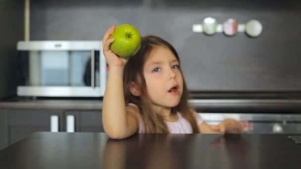 Menina comendo uma maçã verde e sorrindo — Vídeo de Stock