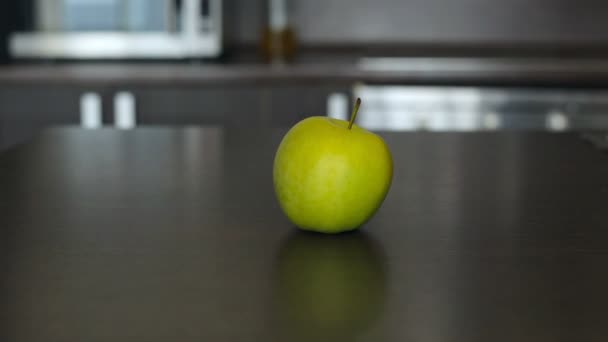 A kislány elérte a zöld alma az asztalon — Stock videók