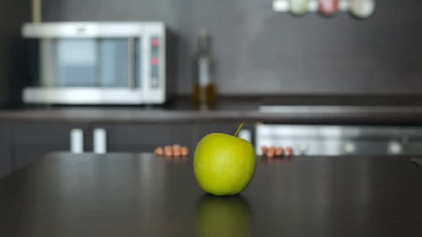 Niña buscando una manzana verde en la mesa — Vídeos de Stock