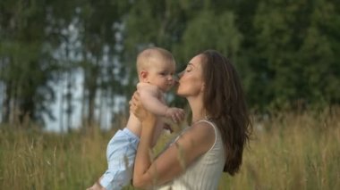 Genç anne üzerinde ellerini küçük bebeği tutar.