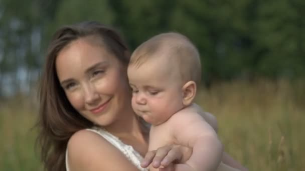 彼女の小さな赤ちゃんを手で保持している若いママ — ストック動画