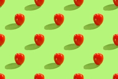 Yeşil arka planda izole edilmiş kırmızı vişneli domateslerden yapılmış kusursuz desen. Sağlıklı organik vegan gıda konsepti. Duvar kağıdı, tekstil, ambalaj, kartpostallar için elverişli