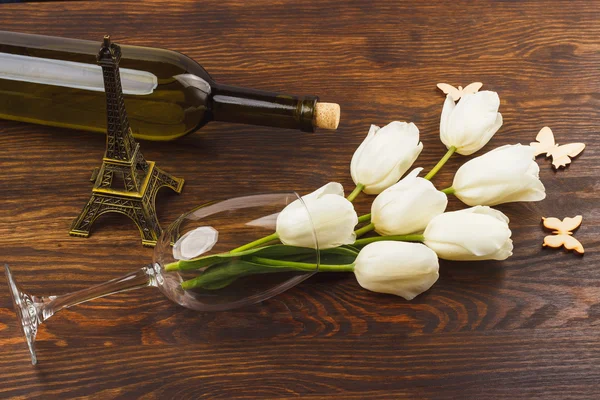 Bicchiere da vino con tulipani bianchi e bottiglia di vino — Foto Stock
