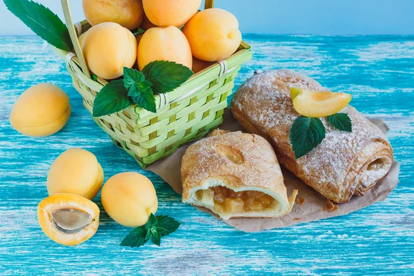 Apricots in the basket and baked goods — Stock Photo, Image