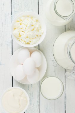 Beyaz tahta tahtalarda farklı süt ürünleri, bulanık arka plan.