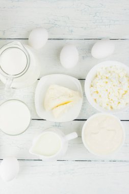 Beyaz tahta tahtalarda farklı süt ürünleri, bulanık arka plan.