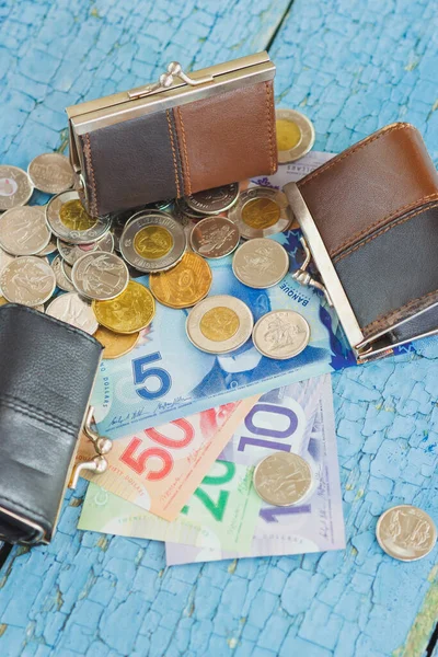 Canadian dollars, coins and wallets on the wooden background, soft focus background