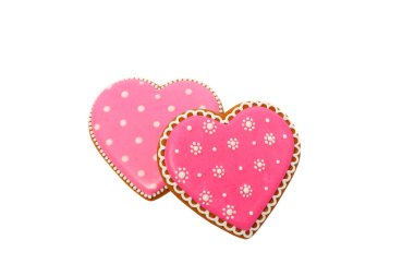 Pembe kurabiyelerin arka planında kalp farklı şekillerde, beyaz renkte izole edilmiş.