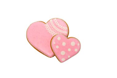 Pembe kurabiyelerin arka planında kalp farklı şekillerde, beyaz renkte izole edilmiş.