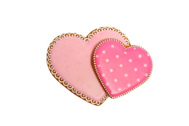 Pembe kurabiyelerin arka planında kalp farklı şekillerde, beyaz renkte izole edilmiş.