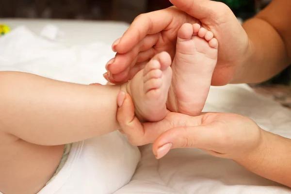 Las Manos Mujer Sostiene Los Pies Del Bebé Fondo Enfoque — Foto de Stock