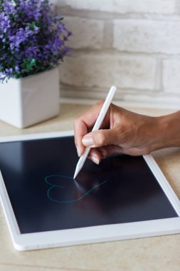 Tablet cihazlı kadın çizimi, yumuşak odaklı arkaplan