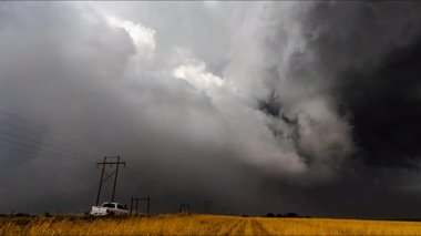 Doğanın ham gücünü ve güzelliğini gösteren sinematik fırtına görüntüleri, dönen süper hücreler, canlı şimşekler, dramatik gökyüzü altında şiddetli yağmur. Kara bulutlar ve ışık parlamaları yoğun, atmosferik bir hava göstergesi yaratır..