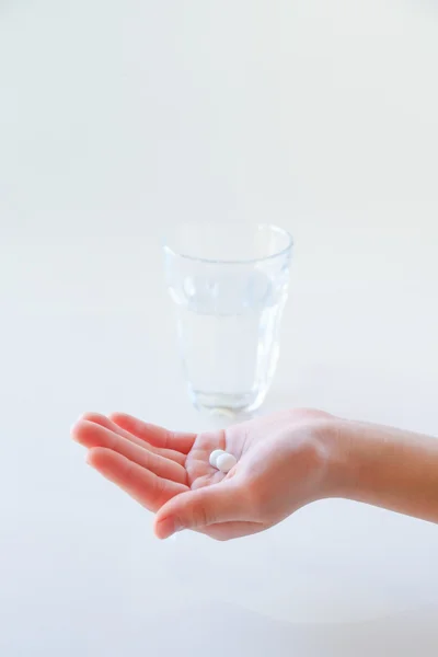 Mãos e água com um medicamento — Fotografia de Stock