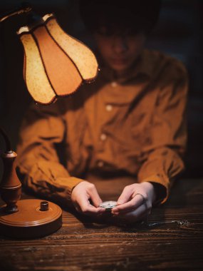 Bir cep saatini tutan.