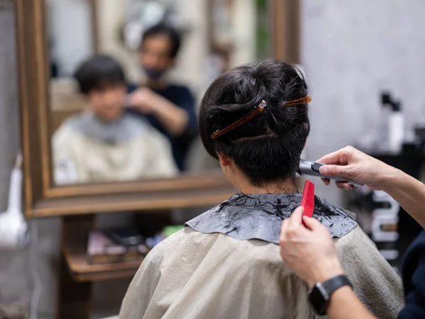 man cutting hair in japan