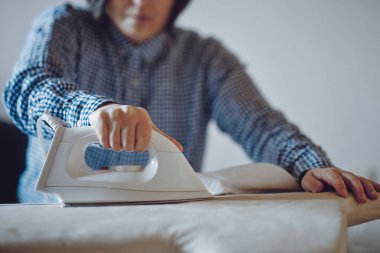 Evde ütü yapan kadın.