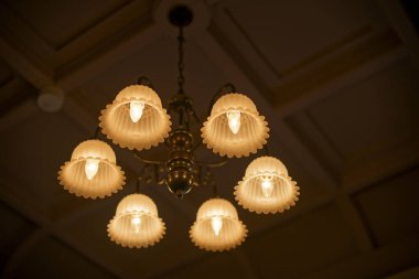 Karanlık odada antik bir avize.