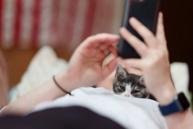 Evin sahibinin yanında kedi yavrusu var.