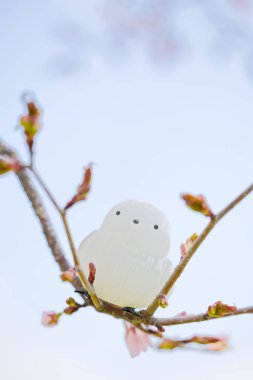 A figurine of a long-tailed tit and cherry blossoms
