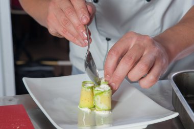 şefler eller ile kabak böreği yemek yaymak