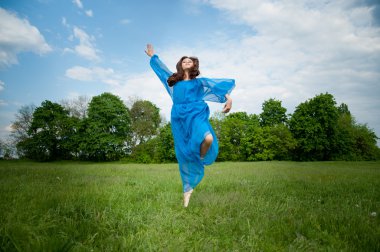 bir alanda zıplama elbiseli kız