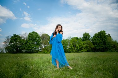 uzun bir elbise tutan bir alanda dans kızı