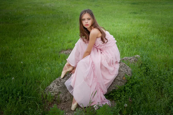 Uzun bir elbise bir taş üzerinde oturan pointe kız balerin amon — Stok fotoğraf